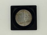 an image of a small silver coin on a black square