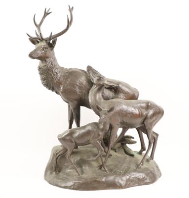 bronze sculpture of a stag and three deers on a rock