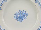 a blue and white plate with a flower design on it