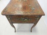 a small wooden table with a floral design on it