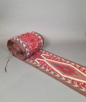 un rouleau de tissu posé par terre à côté d'un rouleau de moquette
