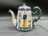 a blue and yellow teapot with a woman on it