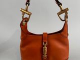 a person holding a brown purse on a white surface