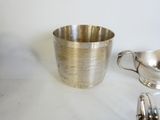 une tasse en argent posée à côté d'une soucoupe en argent sur une table