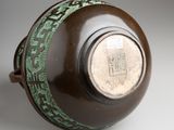 a brown vase with a green design on it
