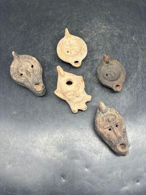 quatre objets anciens posés sur une surface métallique