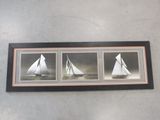 three framed photographs of a sailboat in the water with a sky background