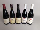 six bouteilles de vin rouge sont alignées sur une table