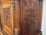 a wooden cabinet with carvings on the top of it