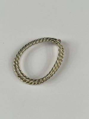 gros plan d'une bague en argent sur une surface blanche