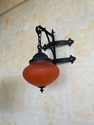 une lampe suspendue sur le côté d'un immeuble