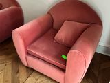 pair of pink velvet chairs in a corner of a room
