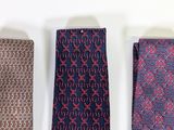 three ties are lined up on a white surface