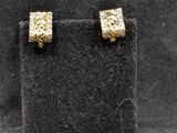 Deux paires de boucles d'oreilles en or sont exposées dans une vitrine.