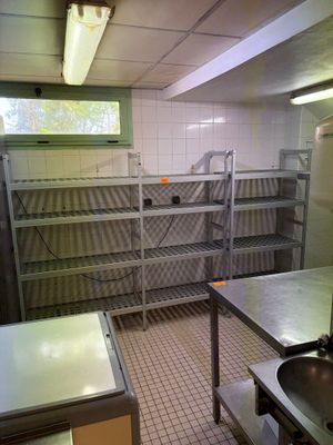 une cuisine équipée d'un évier, d'une cuisinière et d'étagères