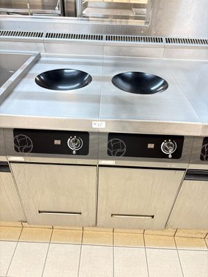 a stainless steel stove top with two burners on it