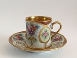 a cup and saucer on a saucer on a white table