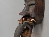an image of a wooden mask hanging on a wall