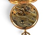 a gold pocket watch with a chain hanging from it ' s side