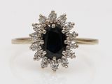 un gros plan d'une bague sertie d'un diamant noir et blanc sur une surface blanche