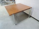 a wooden table with metal legs in a room