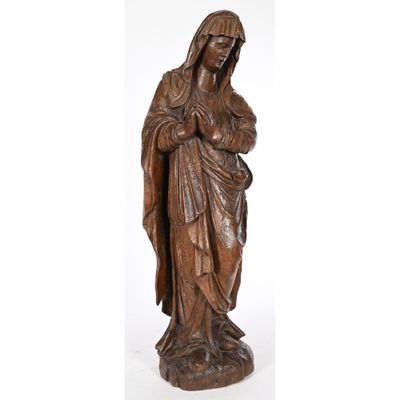 une statue en bois représentant une femme tenant un enfant