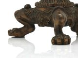 a statue of a lion that is sitting on a white surface