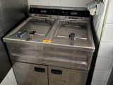 a kitchen with two sinks and a refrigerator in it