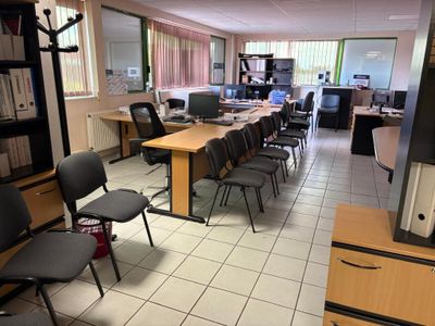 une pièce équipée d'un bureau, de chaises et d'une télévision