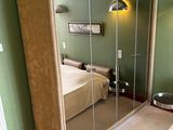 a large mirrored closet in the corner of a bedroom