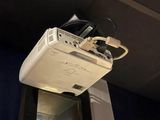 a television mounted on the ceiling above a window