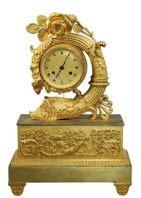 a gold clock that is sitting on a stand