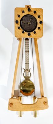 une horloge en bois posée sur un socle et munie d'un pendule