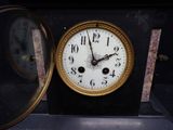 a clock that is sitting on a table with a mirror