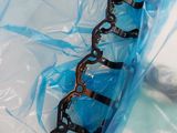 a close up of a blue plastic bag with a chain on it