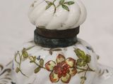 a small glass jar with flowers on it on a plate