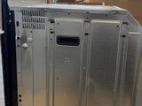 a silver refrigerator sitting on top of a box in a warehouse