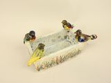 three birds that are sitting on a birdbath
