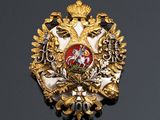 an image of a gold and red broochle on a black surface