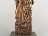 statue en bronze représentant une femme aux cheveux longs, posée sur un socle en marbre