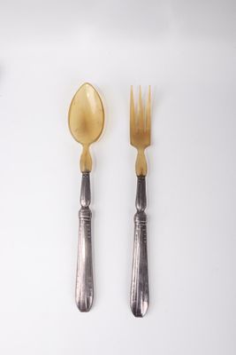 two spoons and a fork on a white table