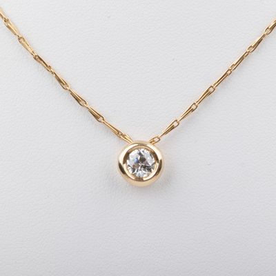 a gold plated necklace with a clear crystal stone on a gold chain