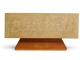 a carved stone plaque with birds on it on a wooden stand