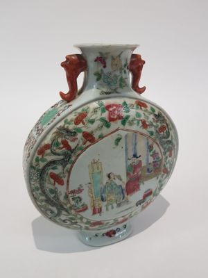 a vase with a painting on it sitting on a table