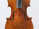 an old violin sitting on top of a white surface