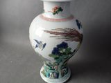 un vase blanc muni d'un couvercle orné de fleurs et d'oiseaux