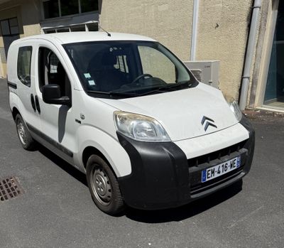 une petite camionnette blanche garée sur le bord de la rue