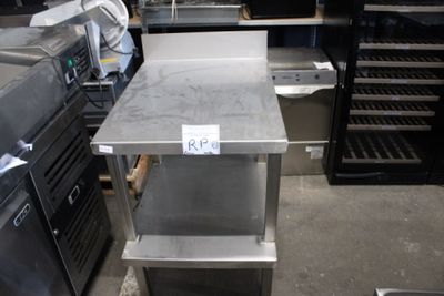 une table en acier inoxydable sur laquelle est posée une étiquette de prix, dans une cuisine