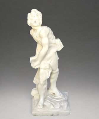 une statue ancienne représentant un homme portant un panier sur le dos