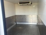 a small room with a toilet and a air conditioner on the wall